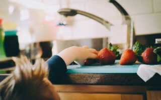 Kind nimmt Erdbeere