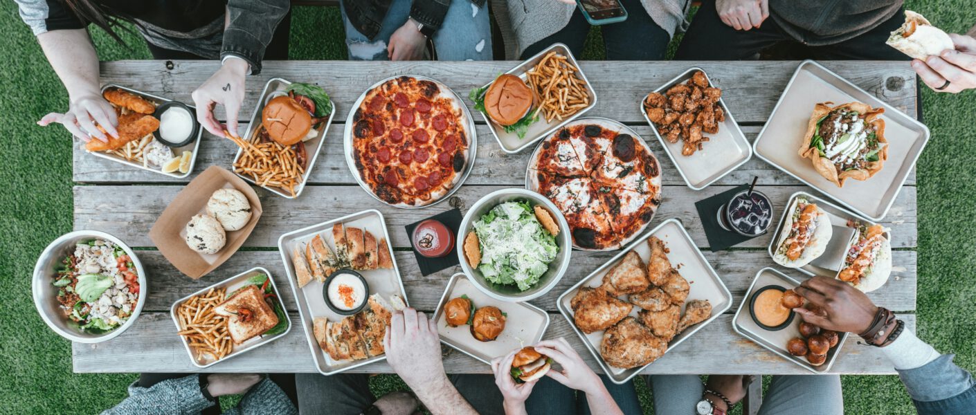 Viele Menschen von oben fotografiert, an einem Tisch. Essen Snacks.