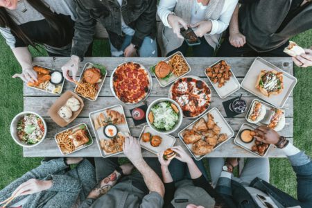 Viele Menschen von oben fotografiert, an einem Tisch. Essen Snacks.